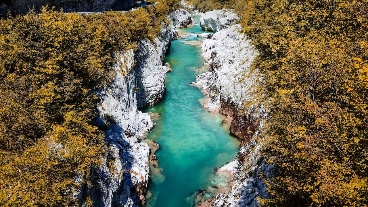 Bright-blue water flowing through a chalk gorge