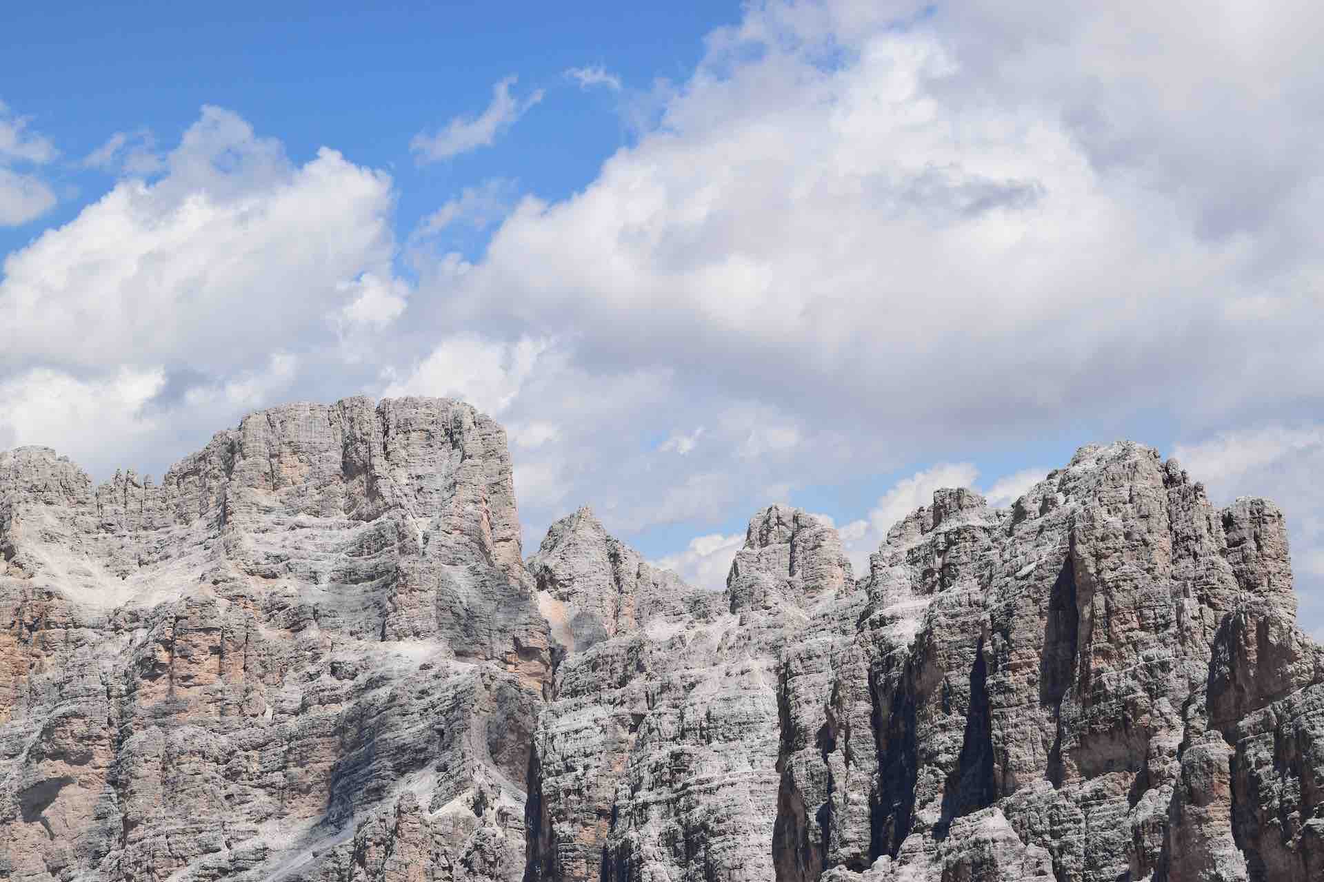 Image of a snow-dappled rocky ridge set against a blue sky