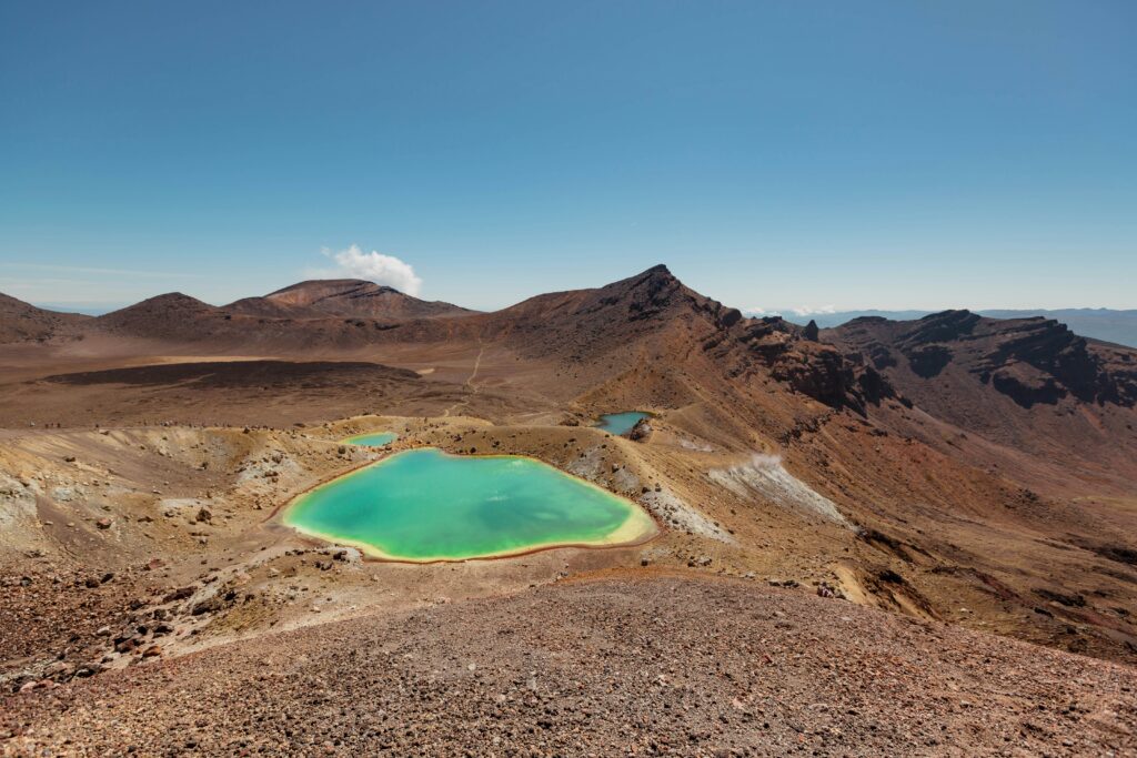 A green lake surrounded by rocky hills in Tongariro New Zealand