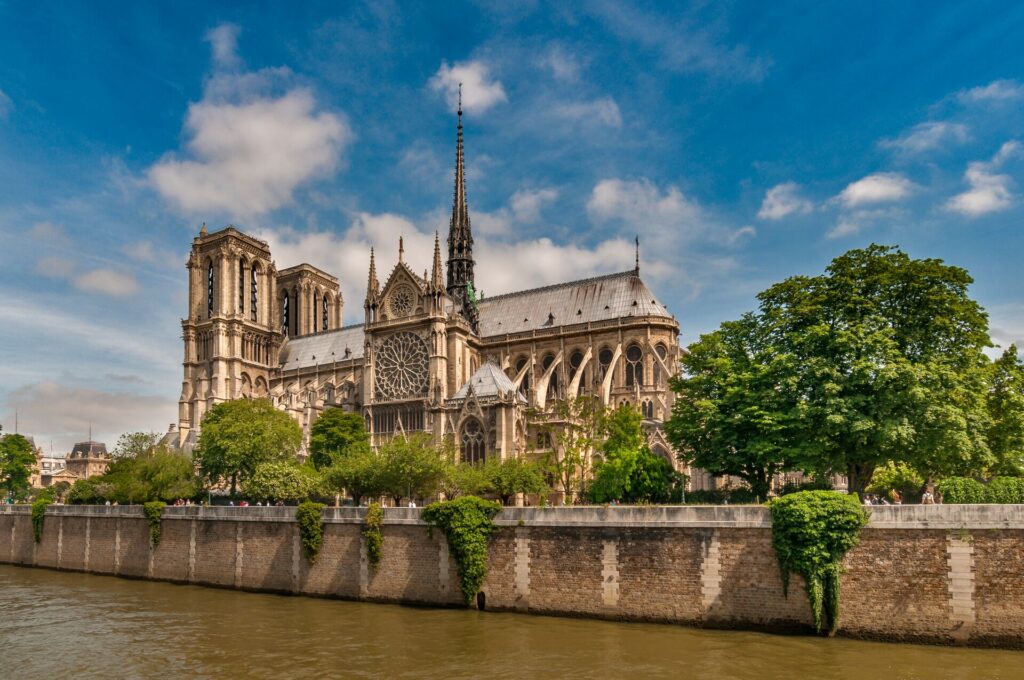 The Notre Dame cathedral stands on the banks of the brown river Seine in Paris.