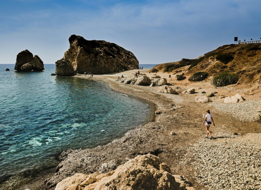 Two huge rocks jut out of a green sea on a Cyprus beach