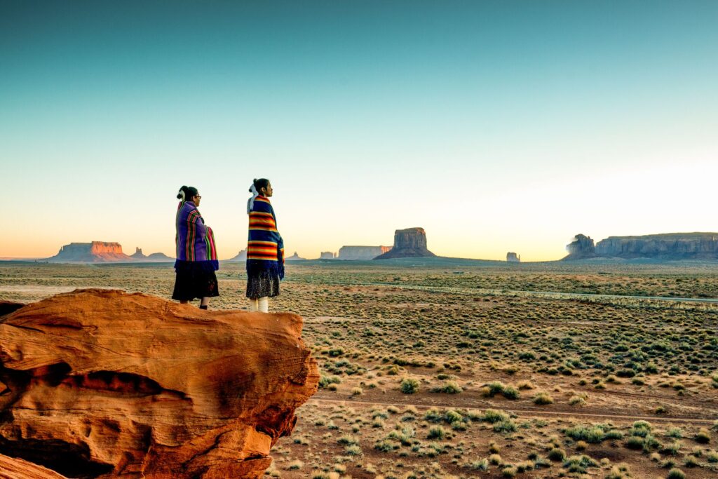 Navajo people standing on canyon in Monument Valley