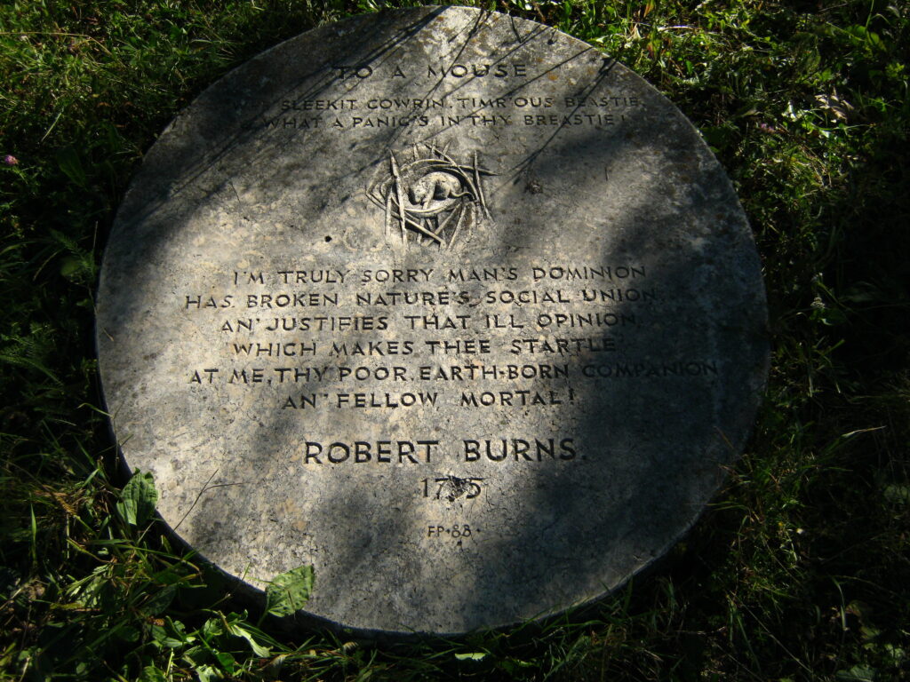 Plaque engraved with a poem by Robert Burns, surrounded by foliage