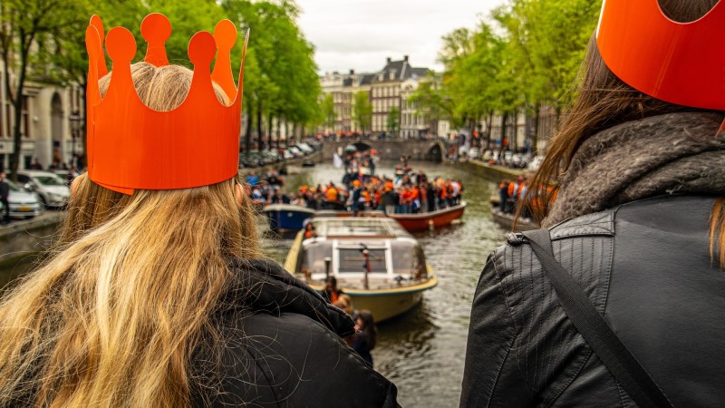 Two young women overlooking boats in an Amsterdam canal