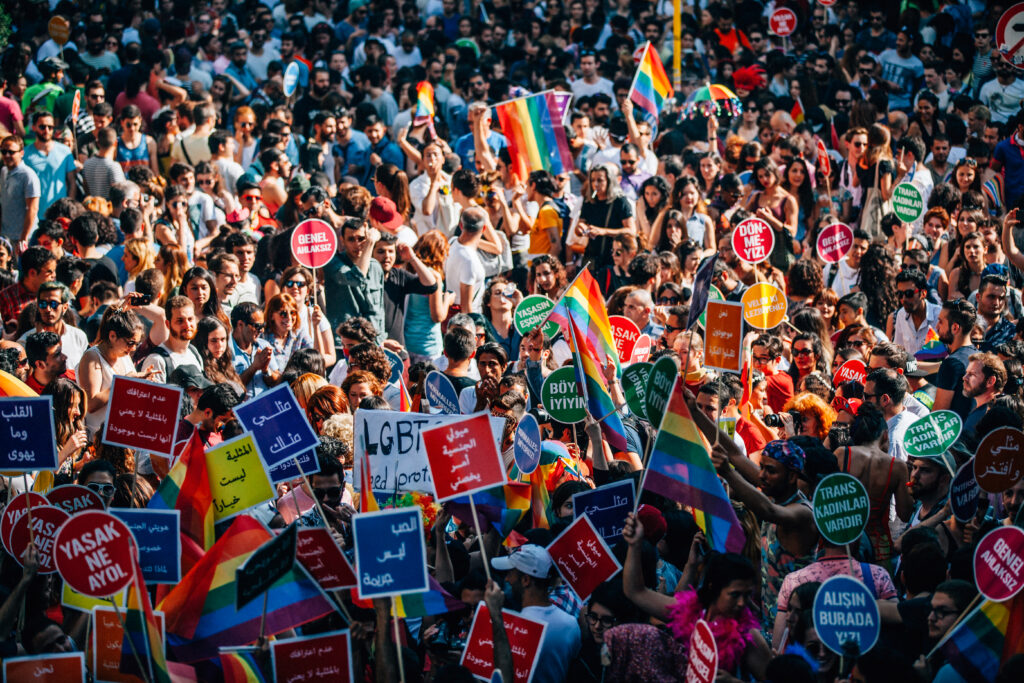 Image of annual Gay pride in Istanbul showing off a multitude of colorful flags and placards calling for equal rights and justice for LGBTQI+ related crime.