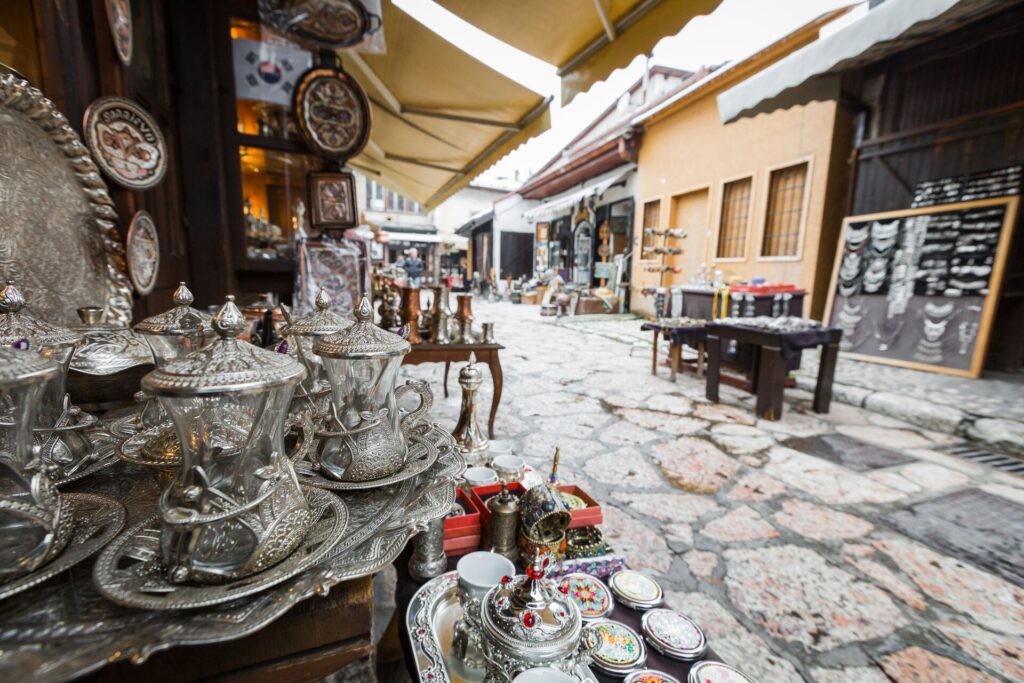 Bosnia craft copper products in the foreground are show on an old market street