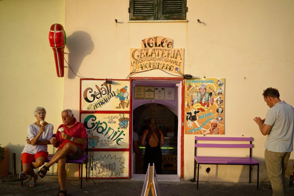A group of people engaged in literary discussions, sitting on a bench outside of a building.