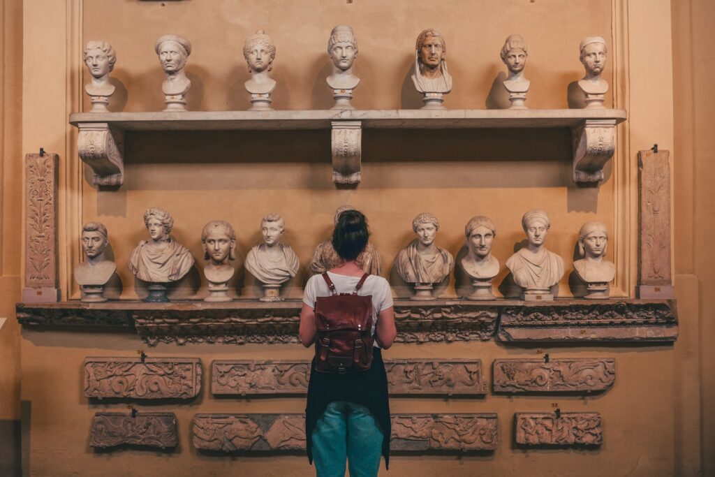 woman looking at Roman stone busts in a museum