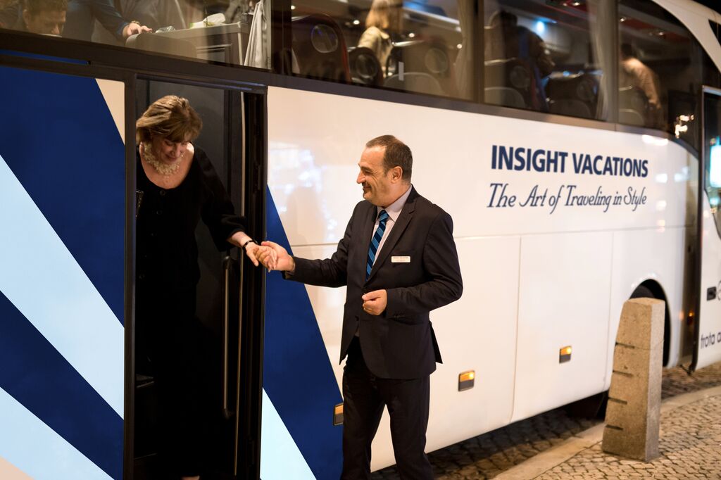 Guest being helped off off a coach by a Travel Director