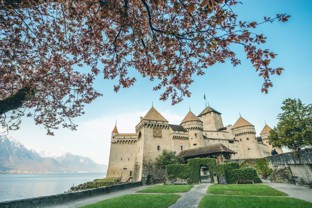 Large castle on the edge of a lake shot against a blue sky