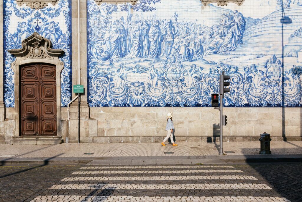 Girl walking in Porto, with a blue and white tiled azulejos wall in background