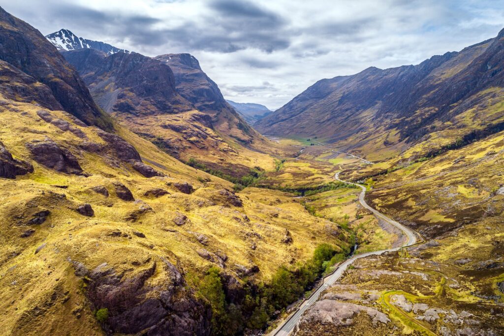 A road winds through the Glencoe Valley in Scotland.