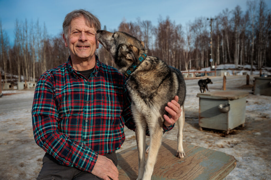 Iditarod musher Martin Buser caresses his sled dog.