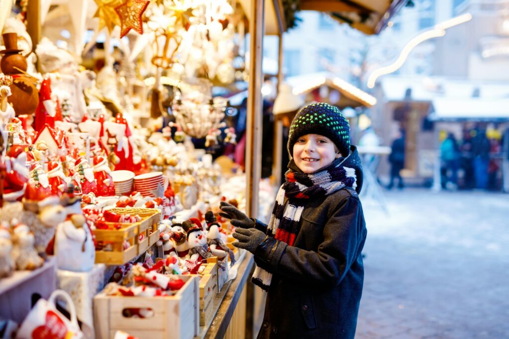 young boy standing near a gift stall at Vienna's Christmas market