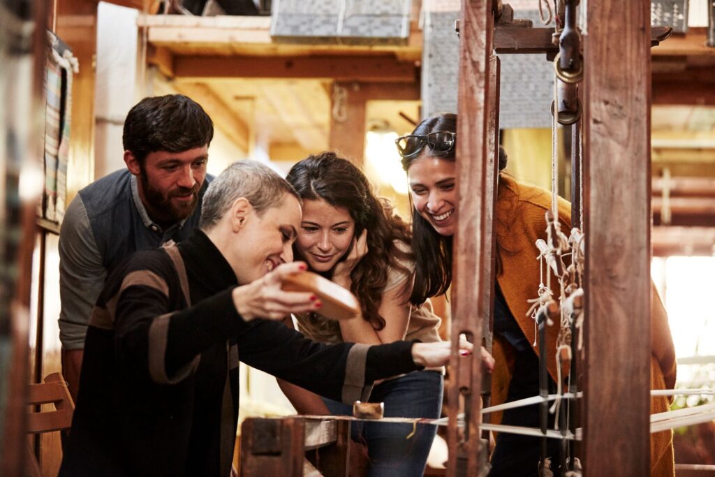 Marta and guests weave at a traditional Perugian loom in Italy - a sustainable travel experience
