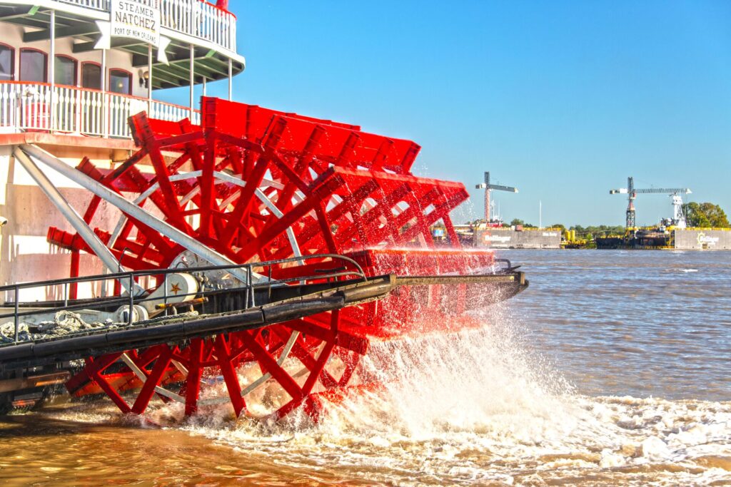 A bright red paddle boat wheel on the river in the Deep South