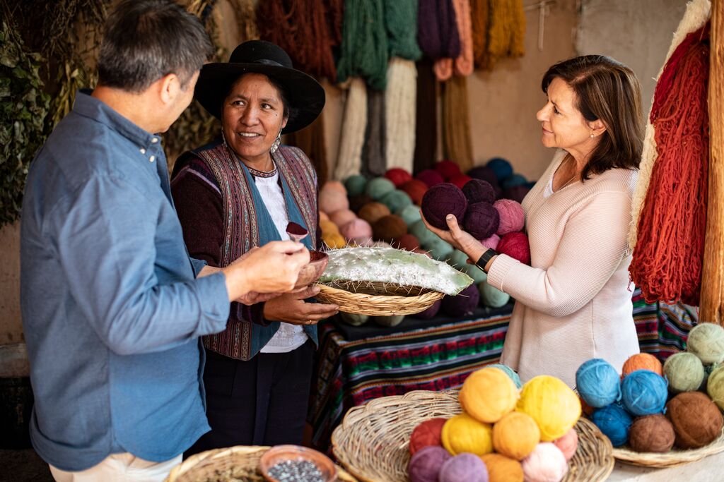 Man and woman meeting a Quechua weaver in Cusco, Peru