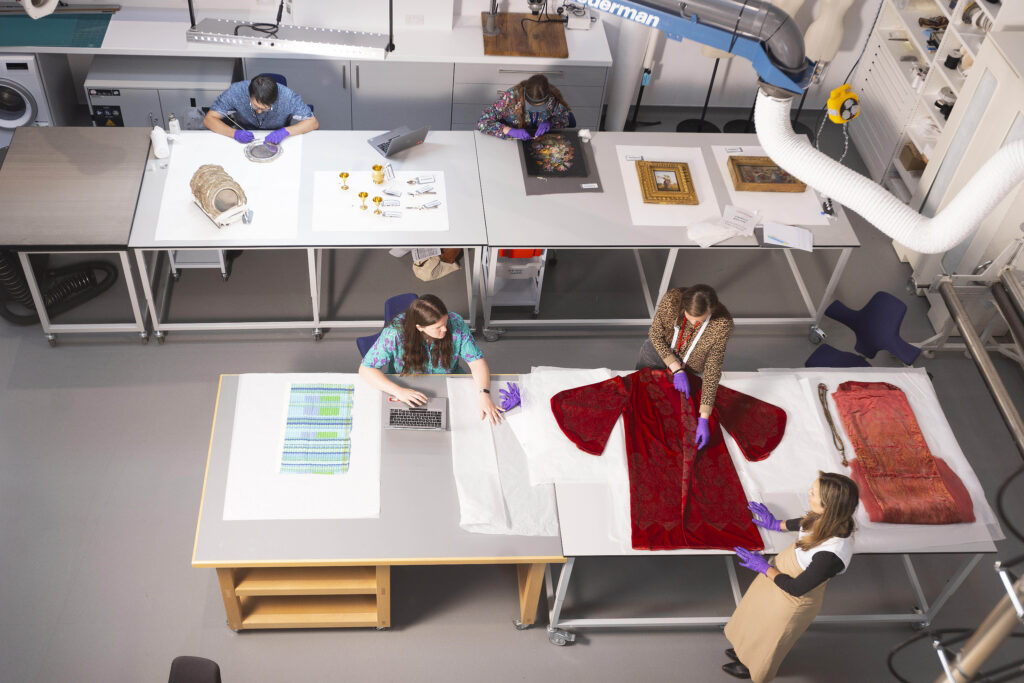Overhead view of museum conservators working on items