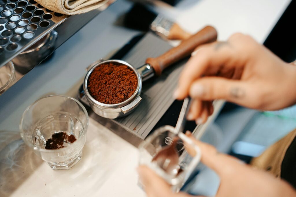 Person's hands putting ground coffee in an espresso maker