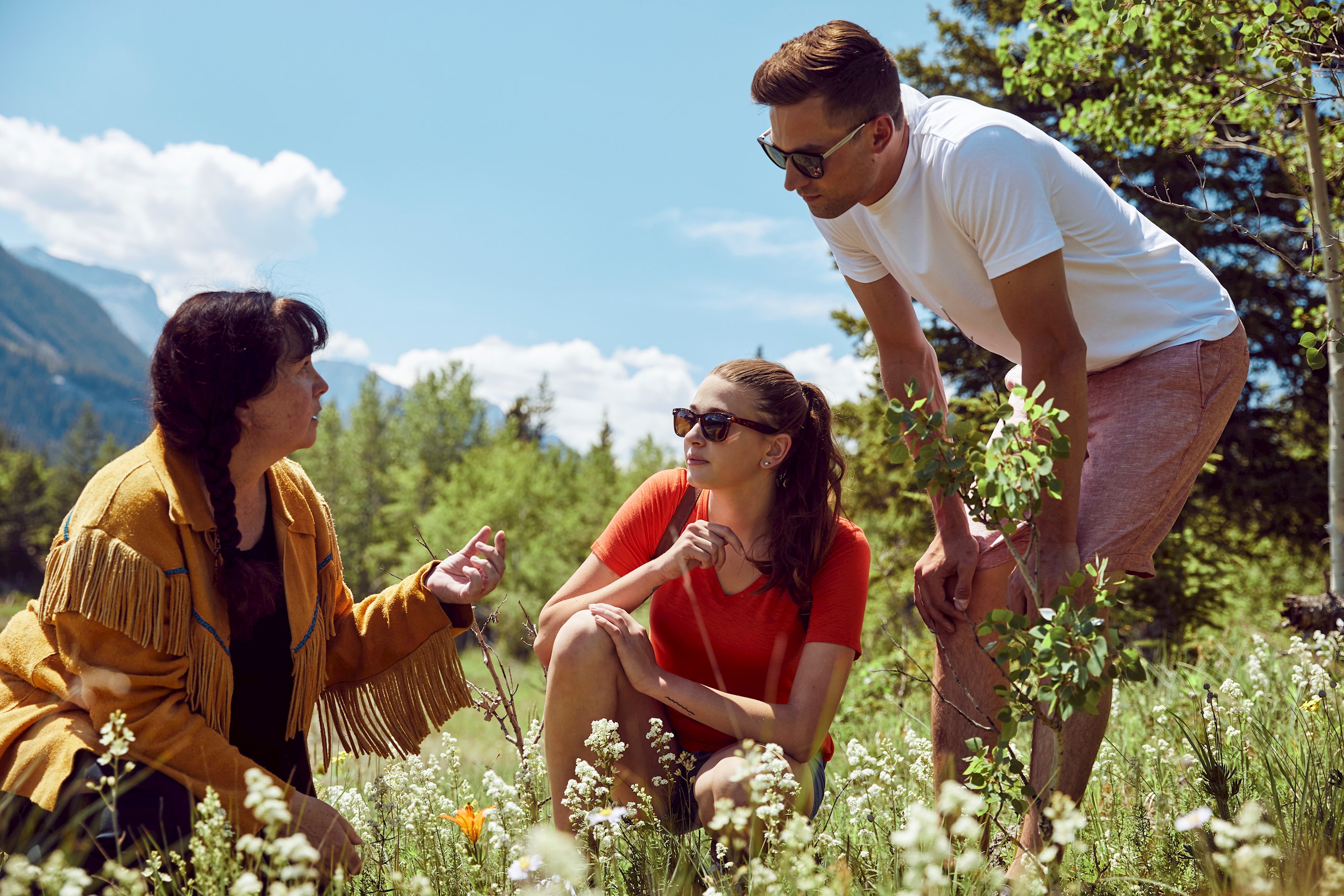 2 tourists learning about local fauna on the Mahikan Trail Plant Medicine Walk in Canmore, Canada