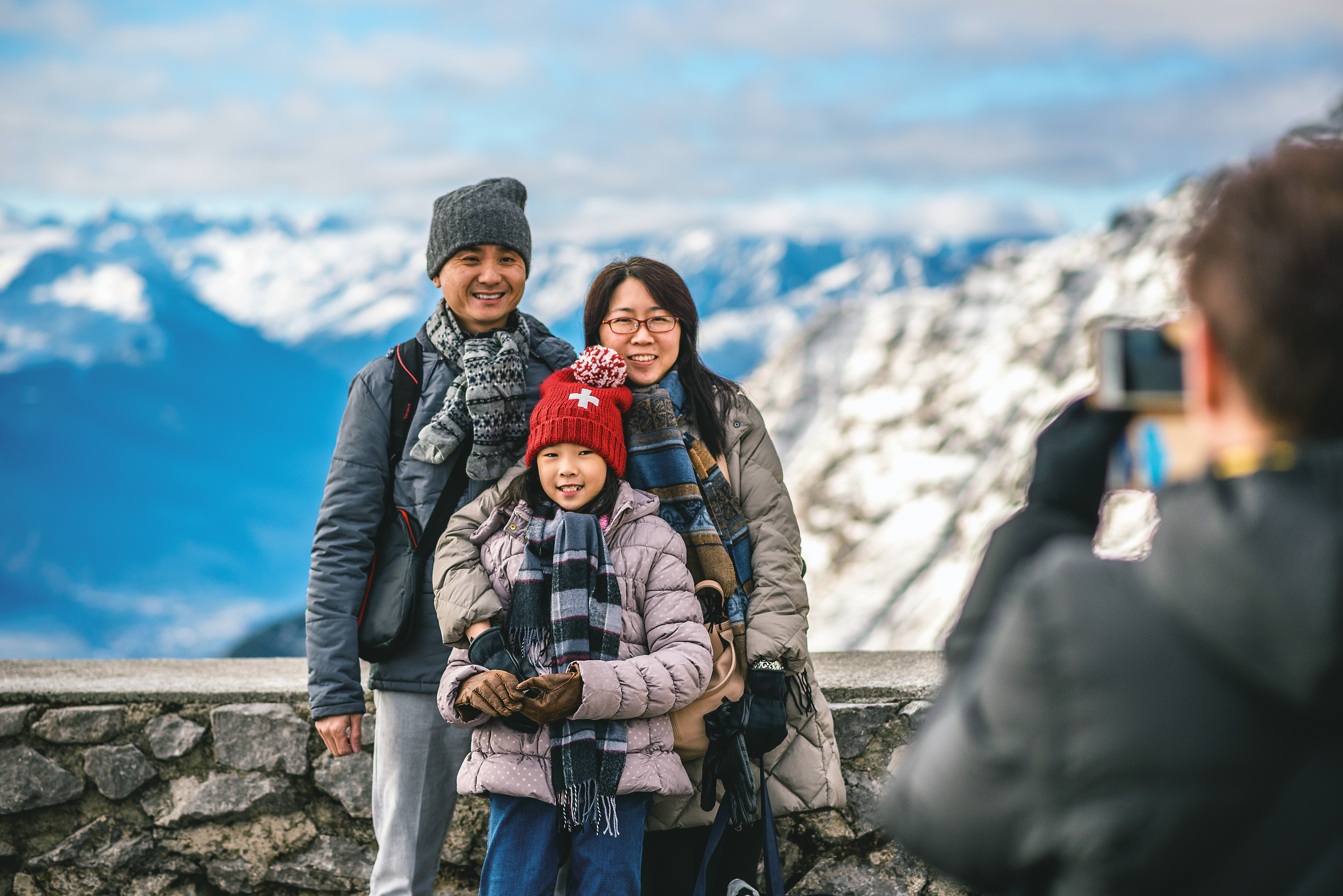 A family posing for a photo in the mountains in winter.