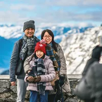A family posing for a photo in the mountains in winter.