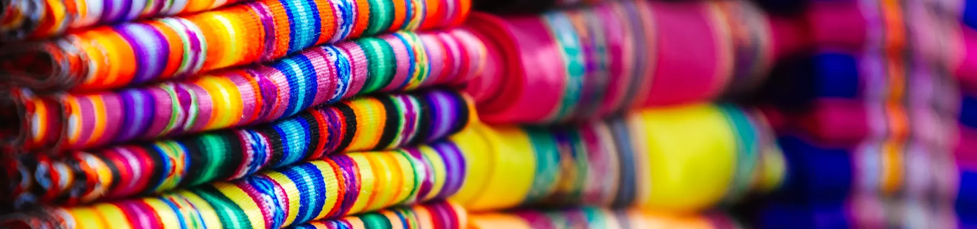 Close Up Of Colorful Blankets Stacked With Andean Designs in Peru, Latin America