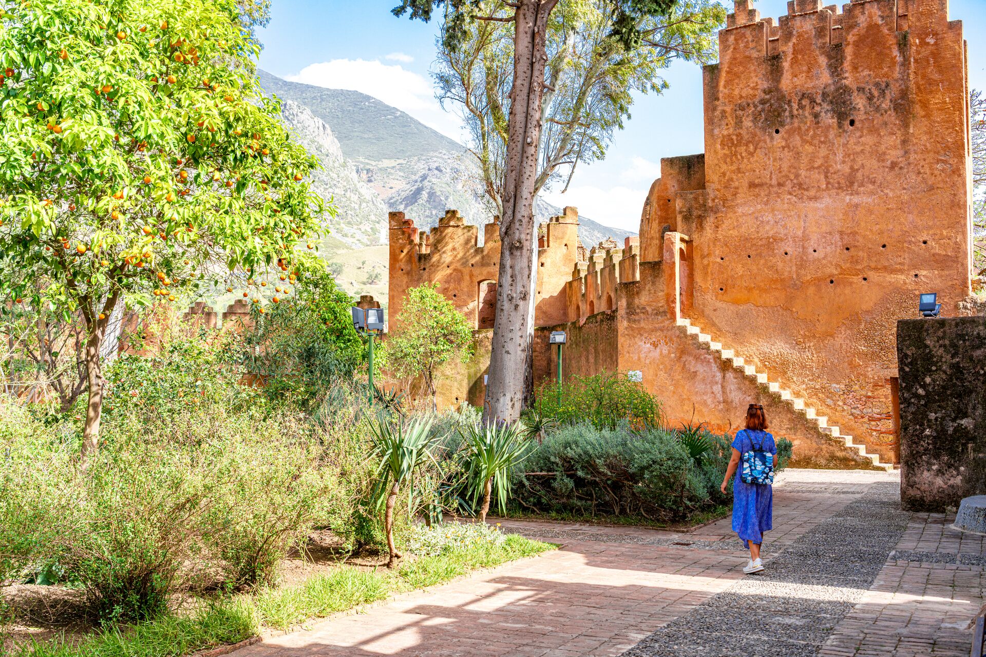 Woman walking to an ancient kasbah fortress in Morocco
