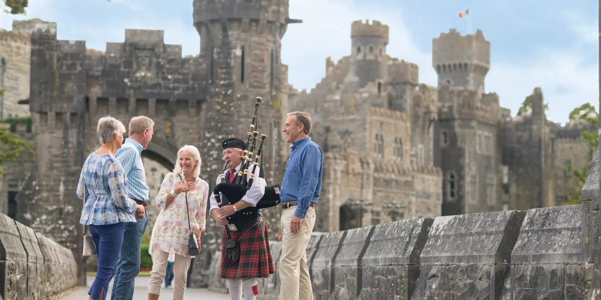 Gests talking to a bagpipe player at Ashford Castle, Ireland