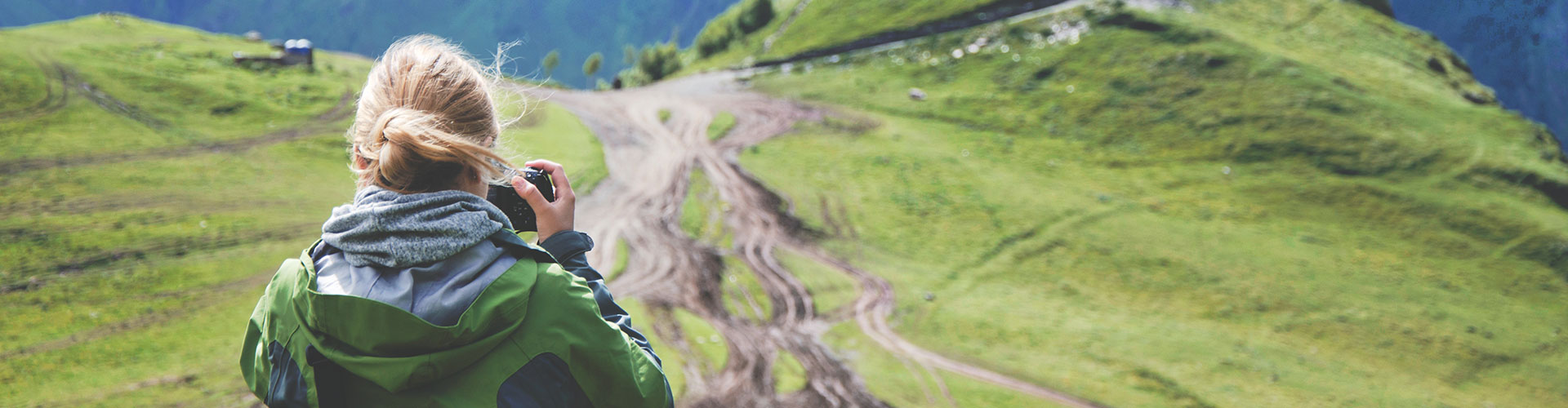 A Woman Taking Pictures At A Hill