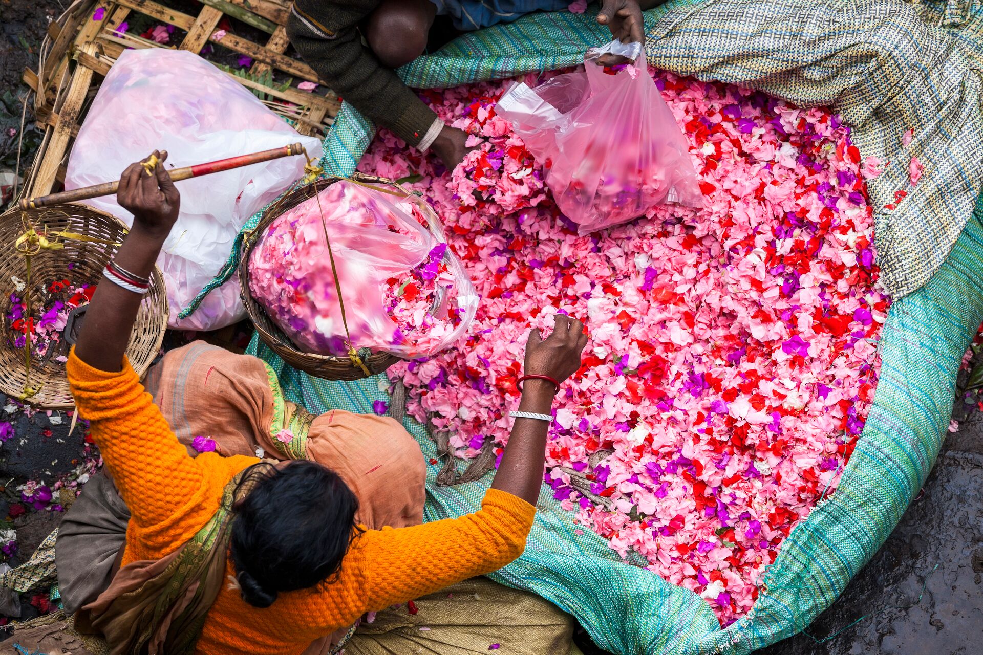 High angle view of a vendor selling pink flower petals at a street market in India