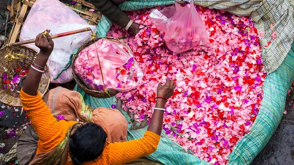 High angle view of a vendor selling pink flower petals at a street market in India