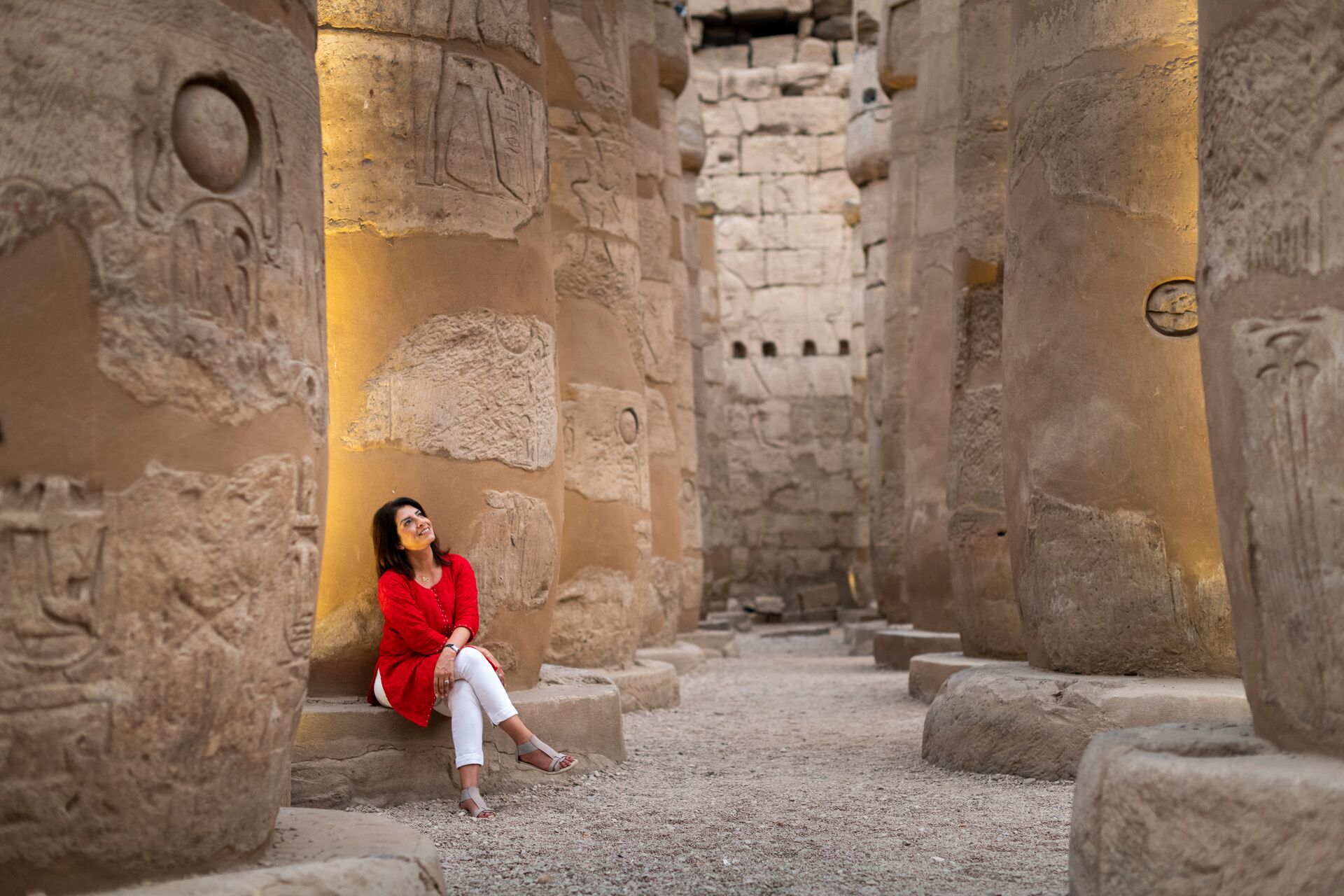 Woman gazing up at huge column in a temple in Luxor, Egypt