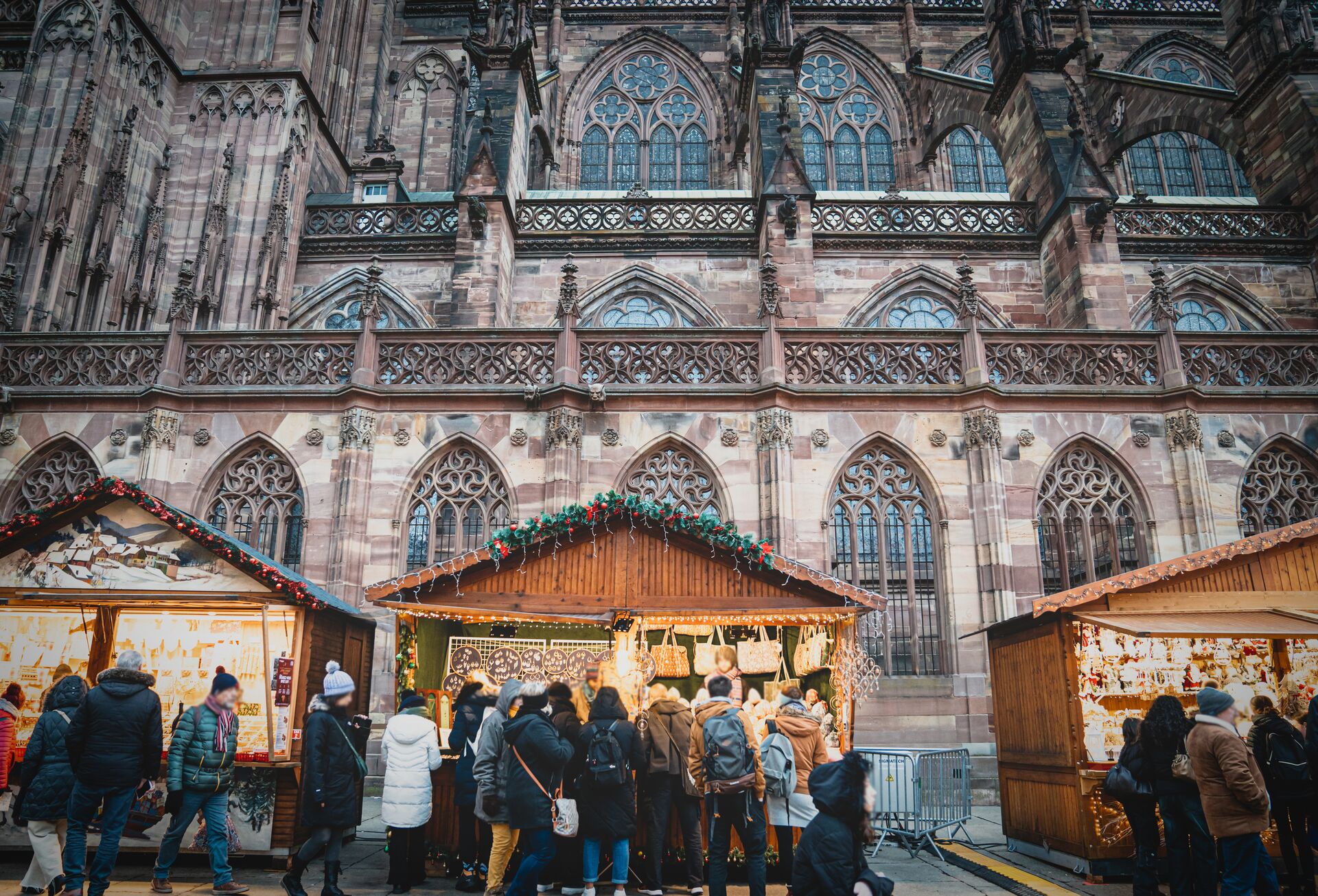 People looking at stalls while attending a traditional Christmas Markets in Strasbourg, France