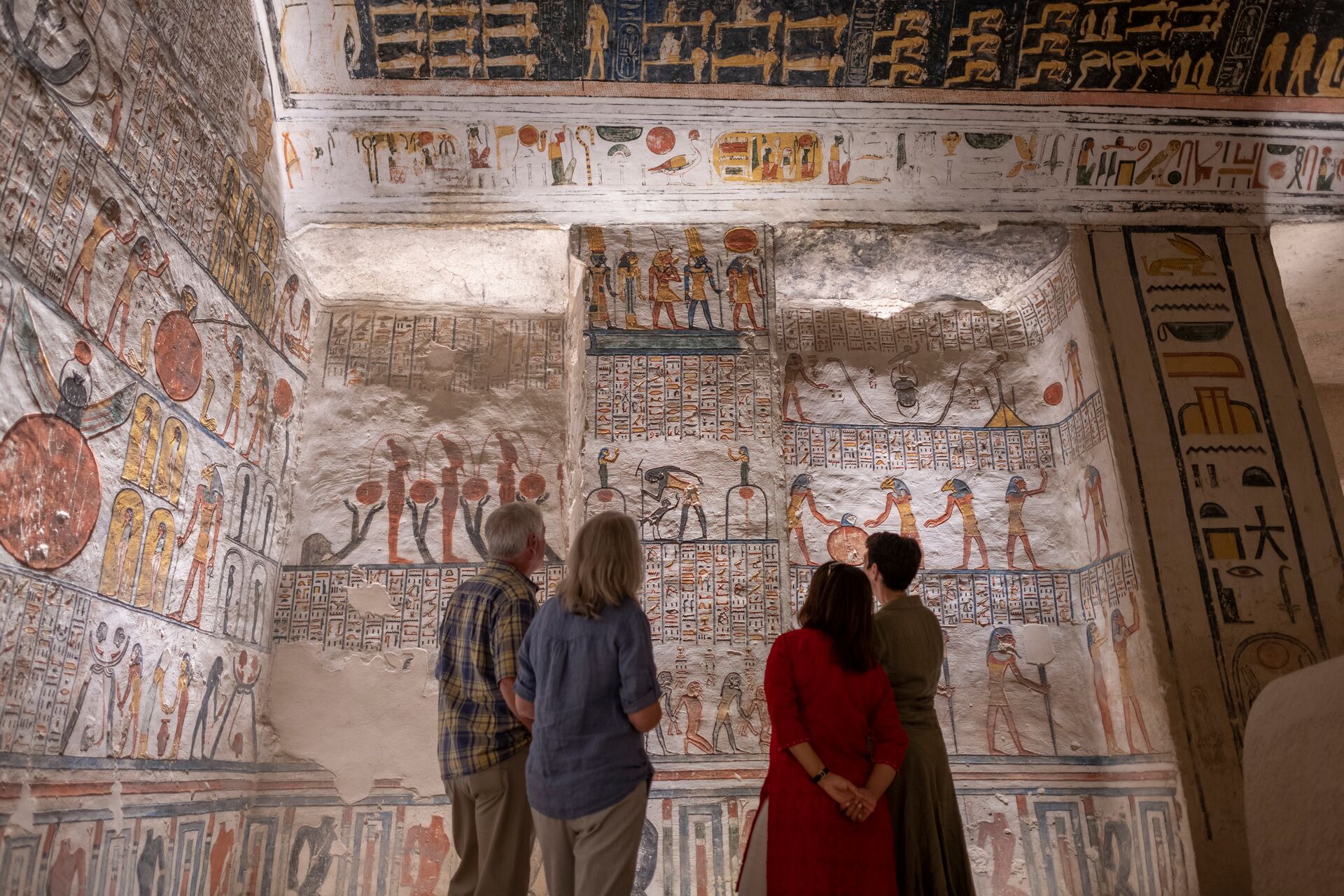 Guests looking at hieroglyphics at thw Ramesses VI Tomb in Luxor, Egypt