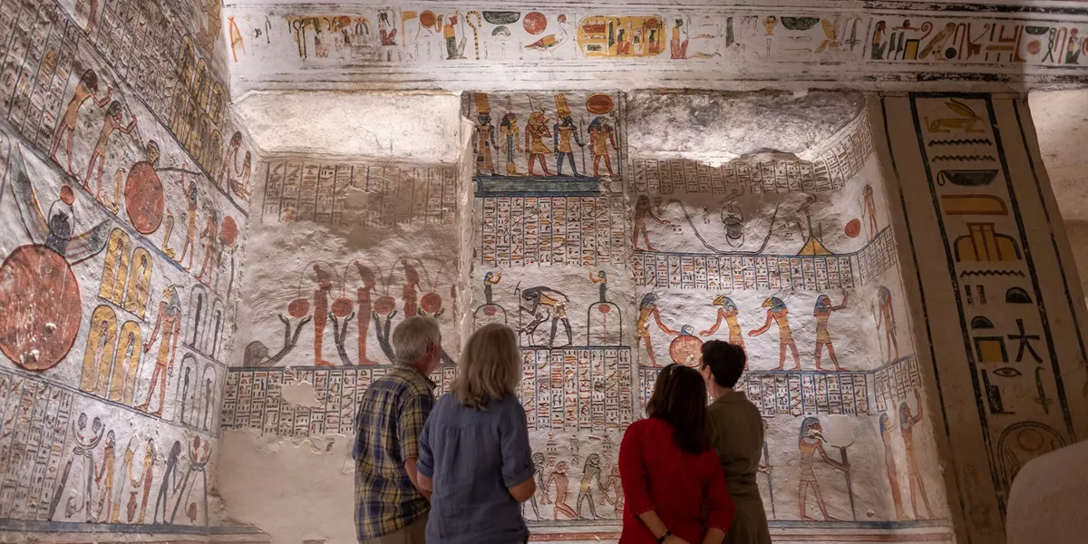 Guests looking at hieroglyphics at thw Ramesses VI Tomb in Luxor, Egypt