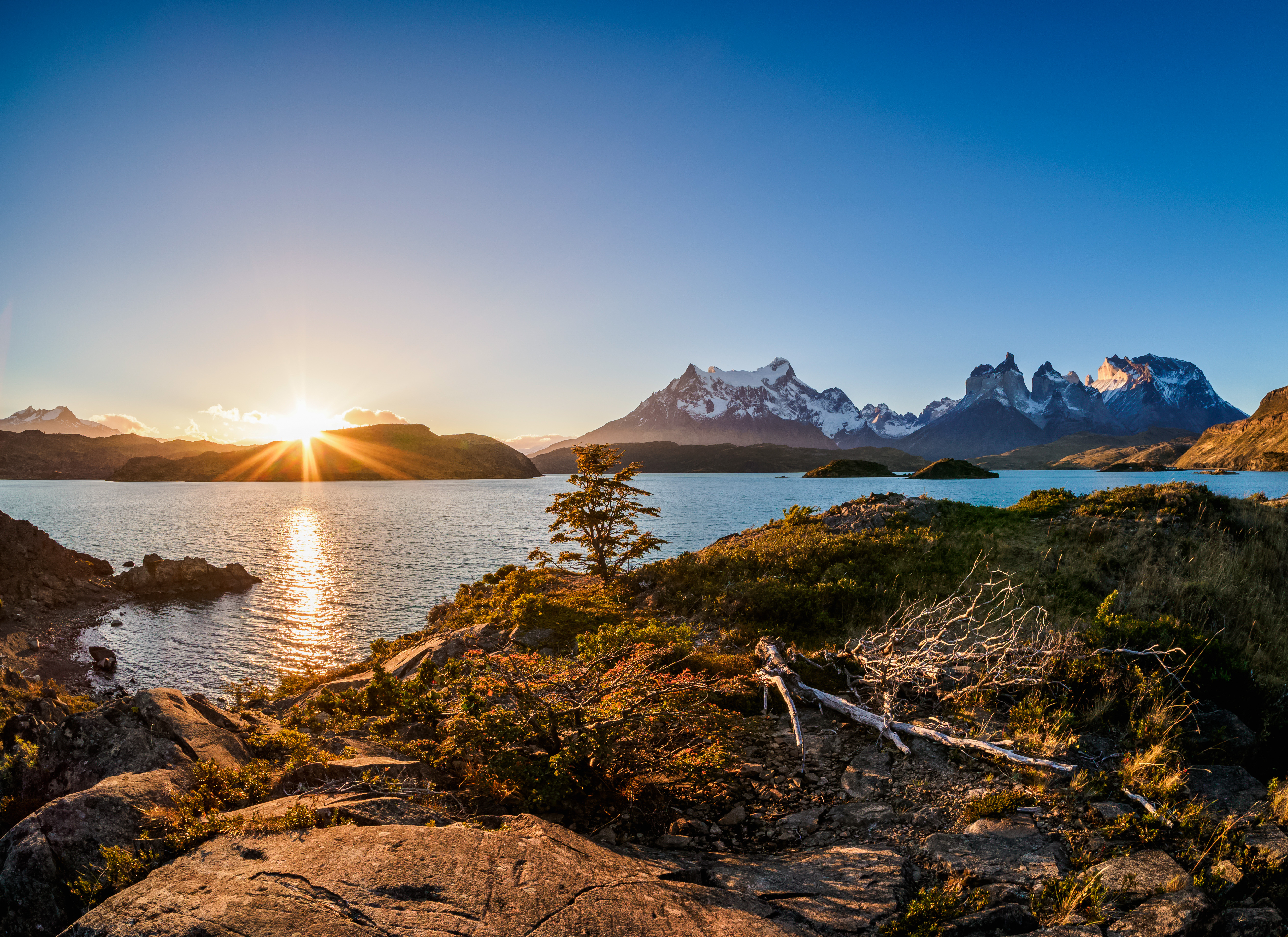 Beautiful sunset over a lake with snow-capped mountains in the background