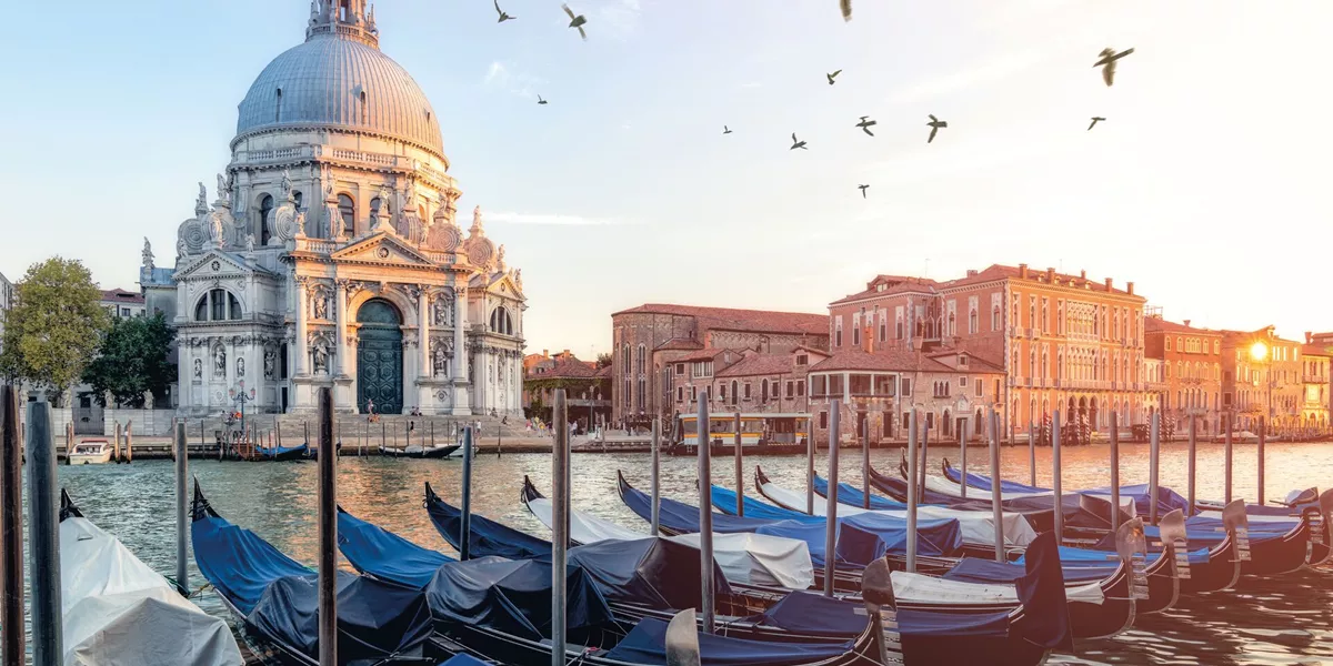 River Side View Of Santa Maria Della Salute Church with gondolas in the foreground in Venice, Italy