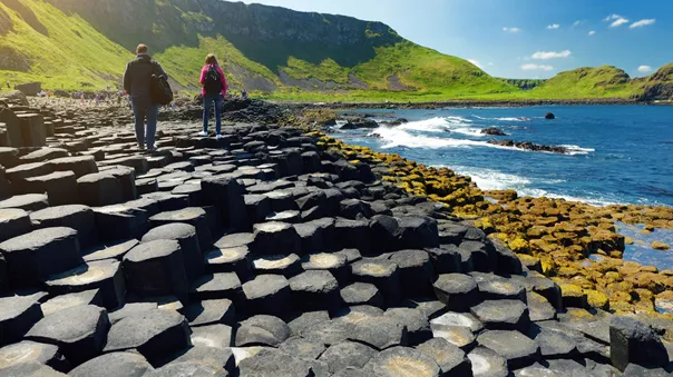 Two Tourists walking at Giants Causeway, a UNESCO World Heritage Site in Northern Ireland