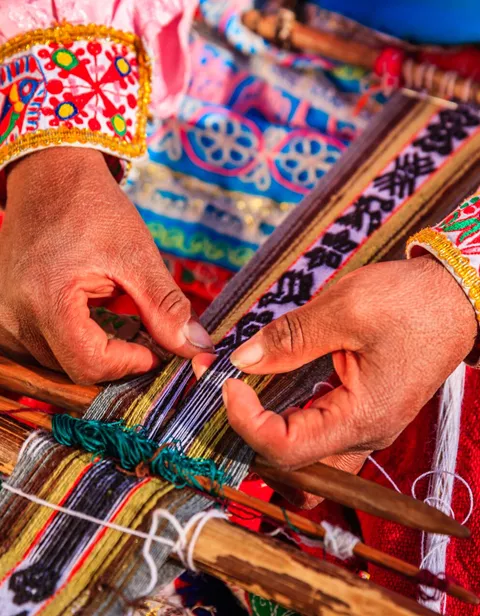 Peruvian woman weaving a traditional garment near Colca Canyon inPeru