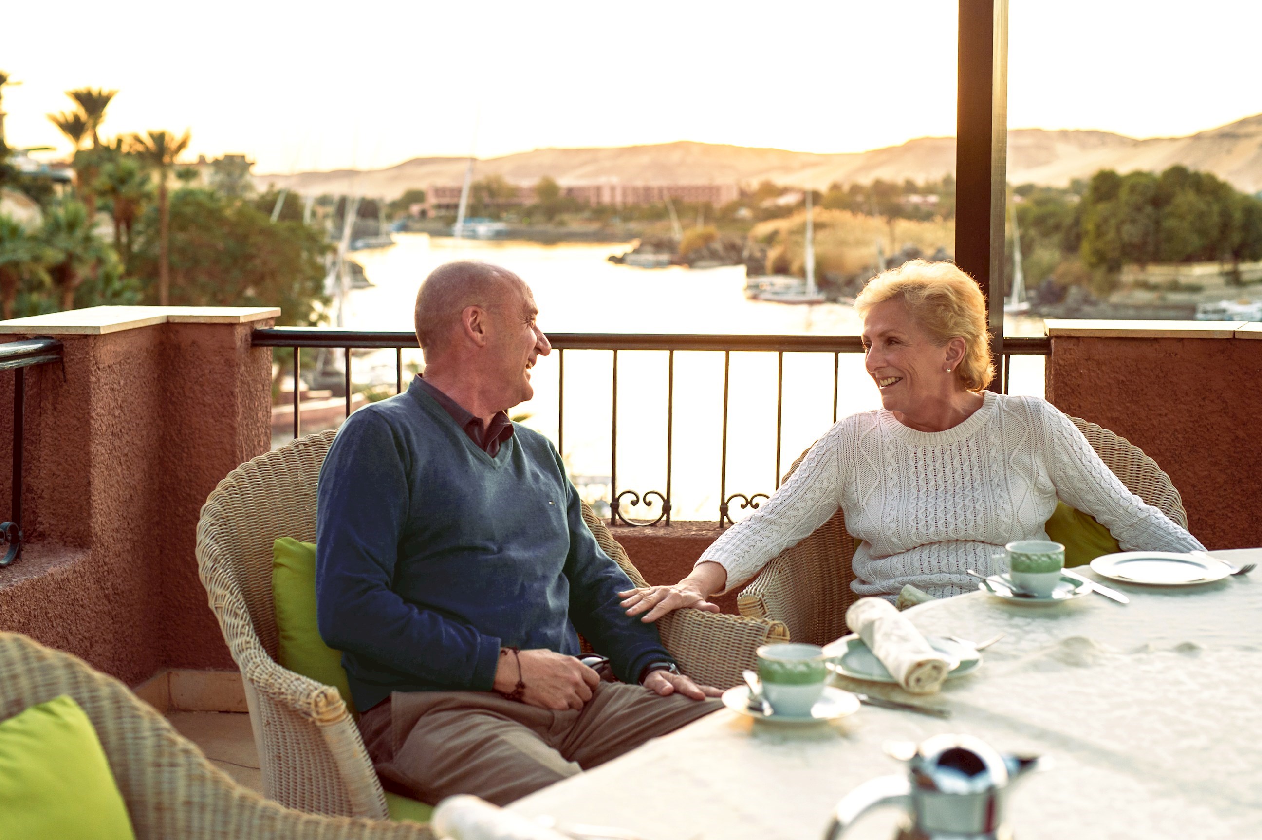 Elderly couple laughing while enjoying high tea at Cataract Hotel in Aswan, Egypt