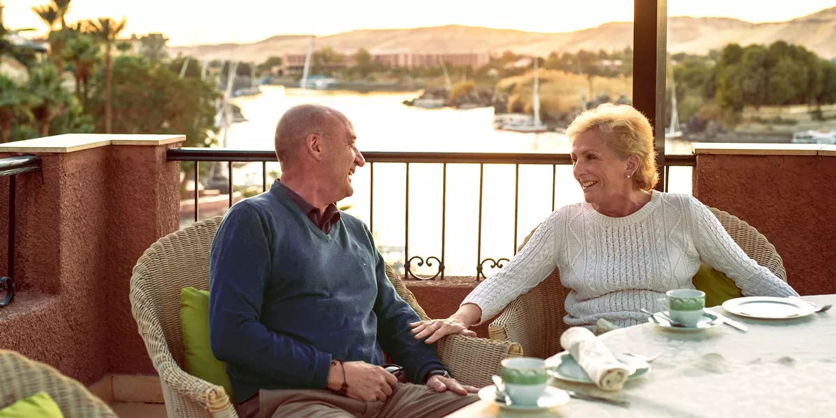 Elderly couple laughing while enjoying high tea at Cataract Hotel in Aswan, Egypt