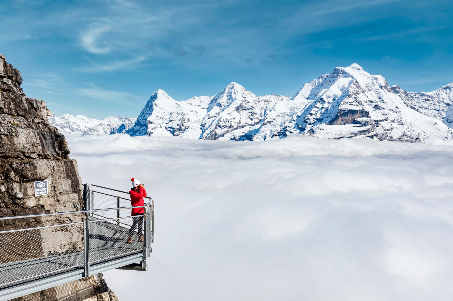 Woman photographing the snowy Swiss Mountains in Switzerland, Europe