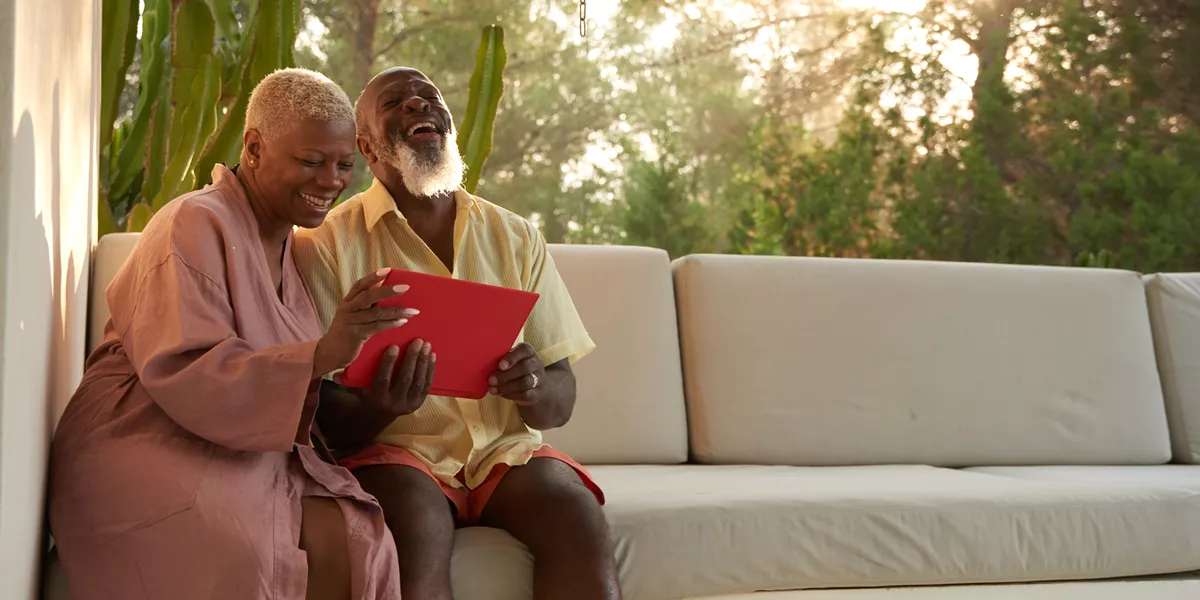 Older Couple Laugh With A Digital Tablet 1192110496