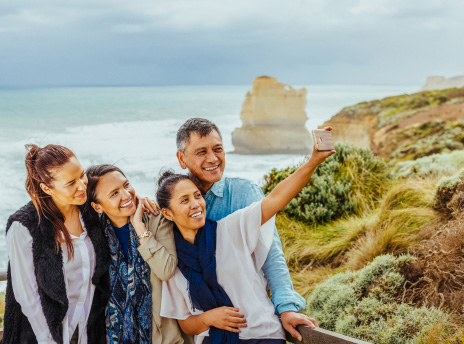A small group of tourists taking selfie on a beach.