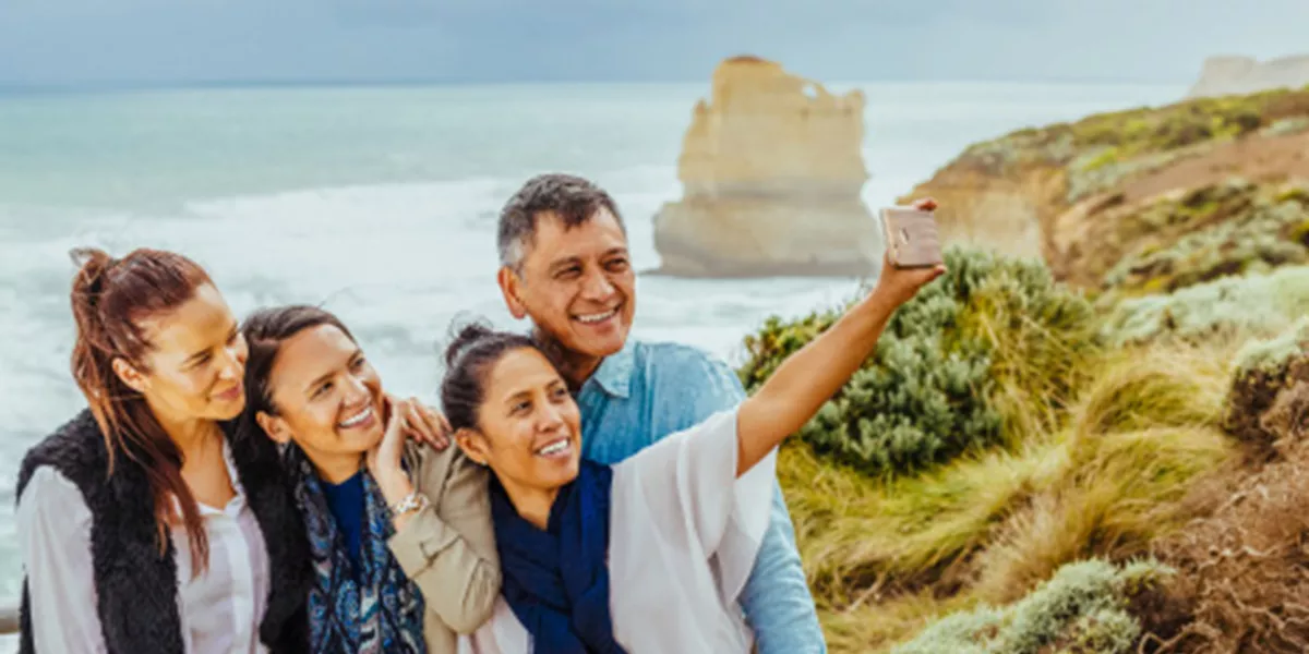 A small group of tourists taking selfie on a beach.
