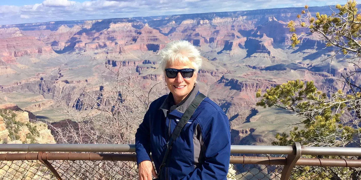 Travel Director Carol standing at a viewing point at the Grand Canyon.