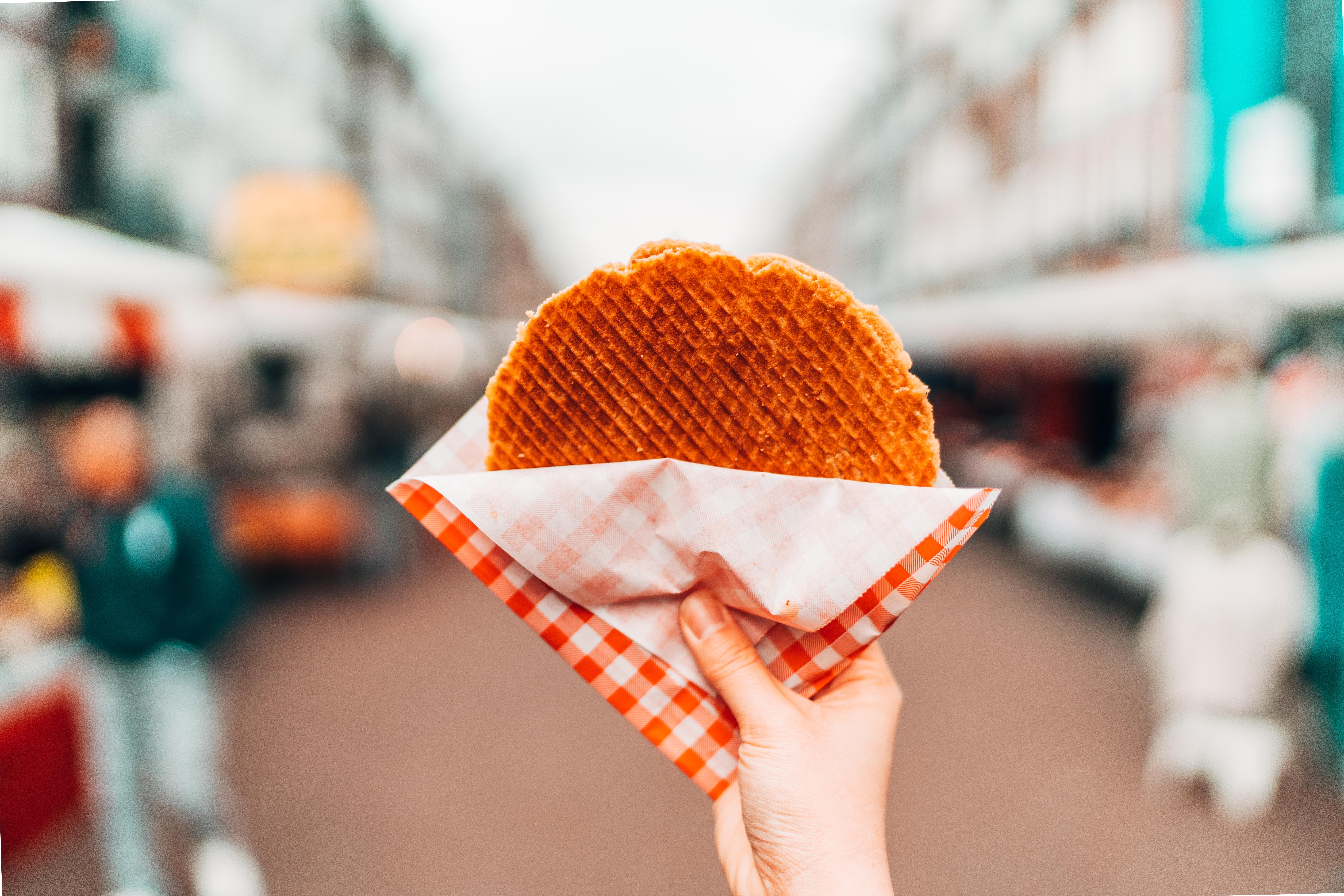 Cropped Hand Holding Waffle In City 1158985928