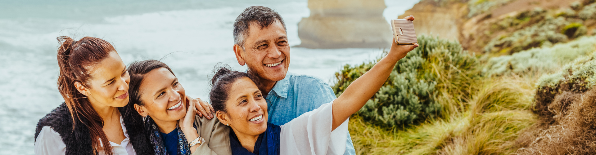 A group of tourists taking a selfie on a beach.