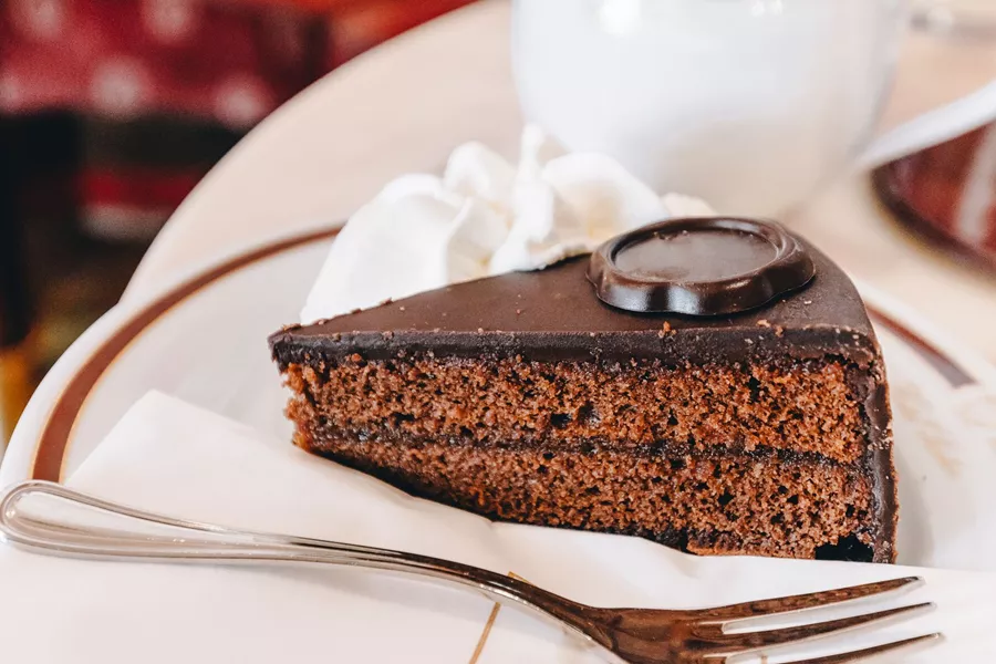 Traditional Austrian Sacher Torte Chocolate Cake Sliced On White Plate